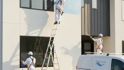 Professional house painters in Indianapolis, IN preparing a home exterior for painting